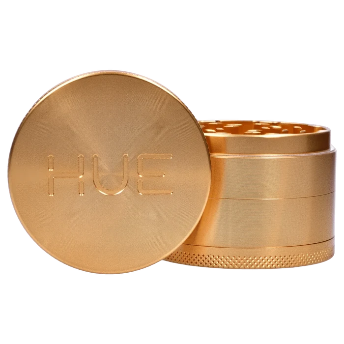 A close-up of the Hue 3-Stage Grinder in champagne gold, showing its stacked, cylindrical design from a slightly elevated angle.